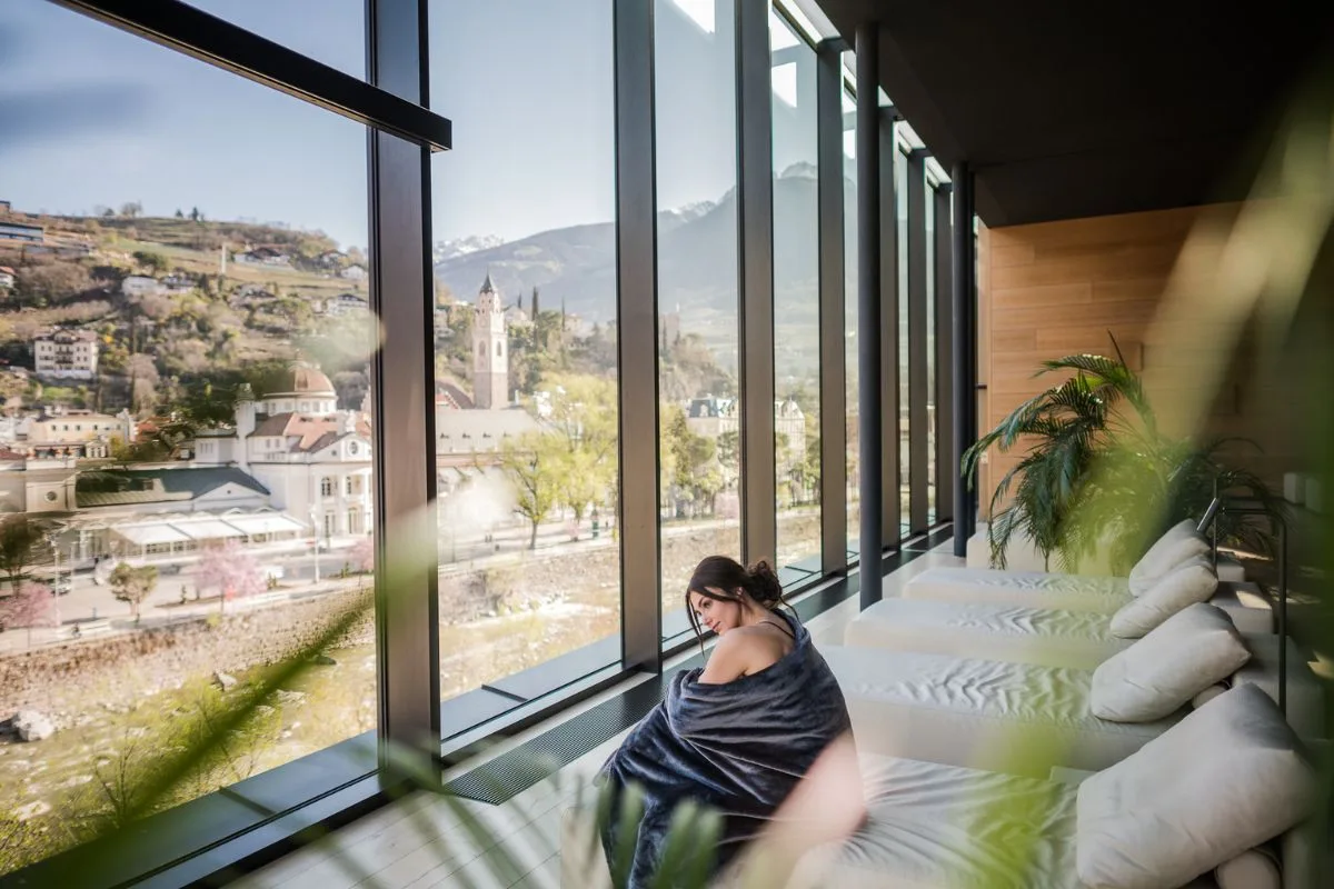 Ruhebereich im Sky Spa mit Liegen am Panoramafenster und Blick über Meran